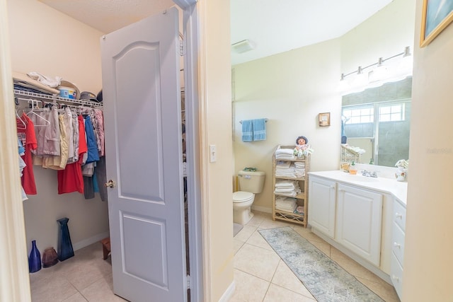 bathroom with vanity, toilet, tile patterned floors, and walk in shower