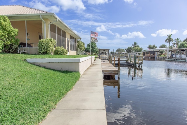 view of dock featuring a water view and a yard