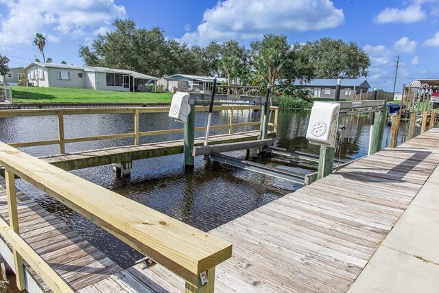 view of dock featuring a yard and a water view