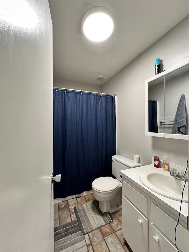 3124 US Highway 441 SE Unit I-4, Okeechobee, FL 34974 - bathroom featuring vanity, stone finish floors, toilet, and a shower with curtain