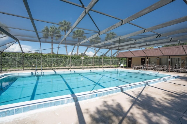 view of swimming pool with a patio area and glass enclosure