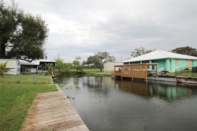 view of dock with a lawn and a deck with water view