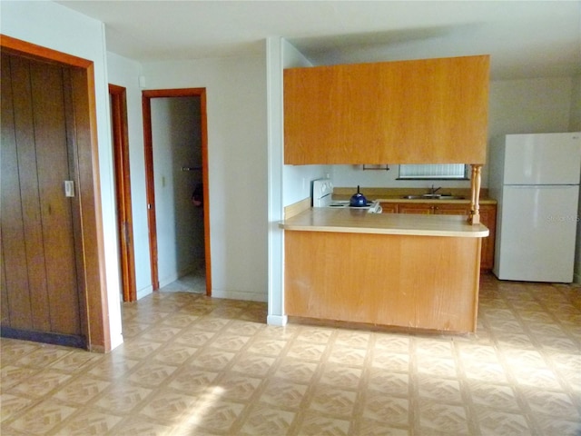 kitchen featuring stove, white fridge, light parquet floors, and sink