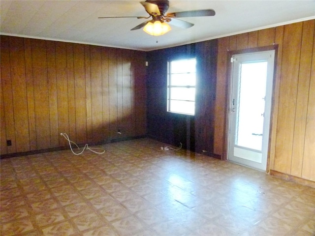 empty room featuring wooden walls and ceiling fan