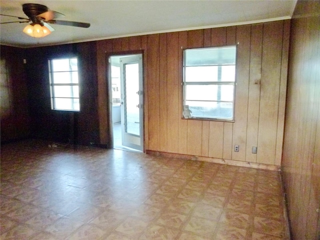 spare room featuring wooden walls and ceiling fan