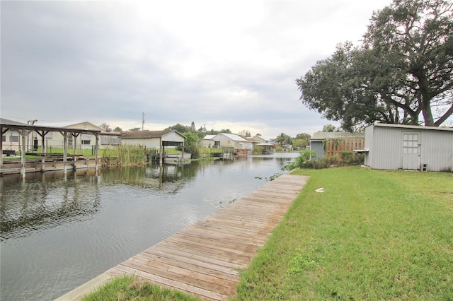 dock area with a water view and a lawn