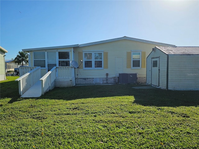 back of property with a lawn, cooling unit, and a shed