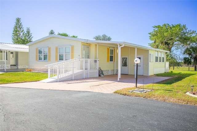 view of front of home with a carport and a front lawn