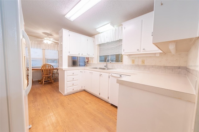 kitchen with white appliances, light hardwood / wood-style floors, white cabinetry, and sink