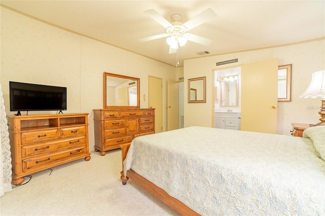 carpeted bedroom with ceiling fan and ensuite bath