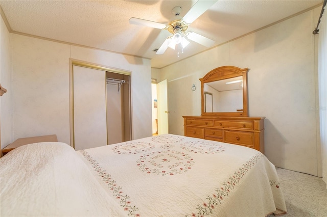 bedroom featuring carpet flooring, ceiling fan, a textured ceiling, and a closet