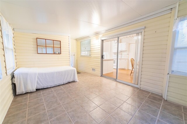 bedroom featuring wooden walls