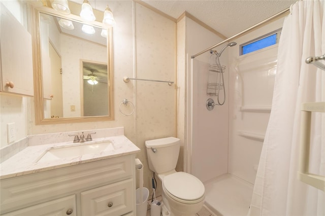 bathroom featuring a shower with shower curtain, vanity, a textured ceiling, ceiling fan, and toilet