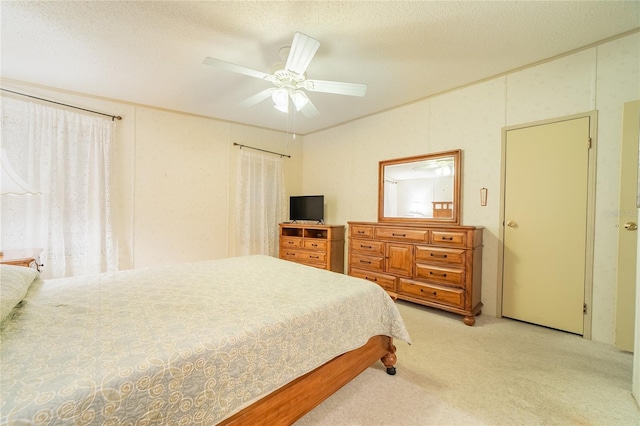 bedroom featuring a textured ceiling, ceiling fan, and light carpet