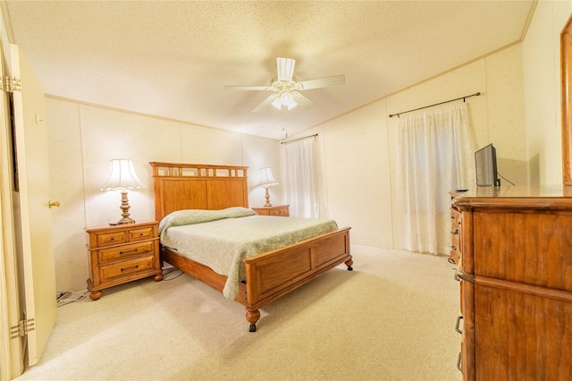 bedroom with ceiling fan, light colored carpet, and a textured ceiling