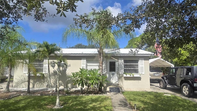 view of front of home with a front lawn and a carport