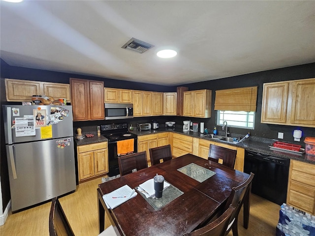 kitchen featuring black appliances, light wood-type flooring, and sink