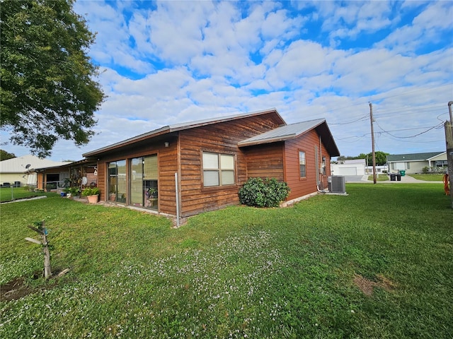 view of side of home featuring a lawn and cooling unit