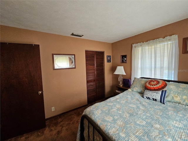 bedroom with dark carpet, a textured ceiling, and a closet