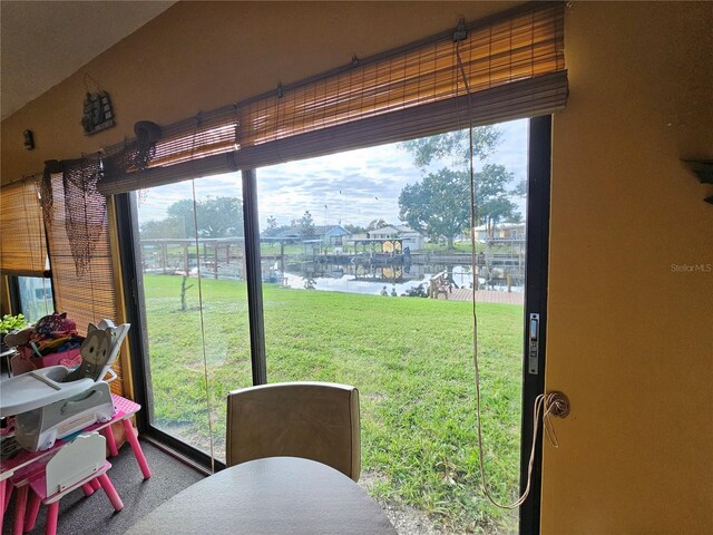 doorway to outside featuring carpet, a water view, and a wealth of natural light