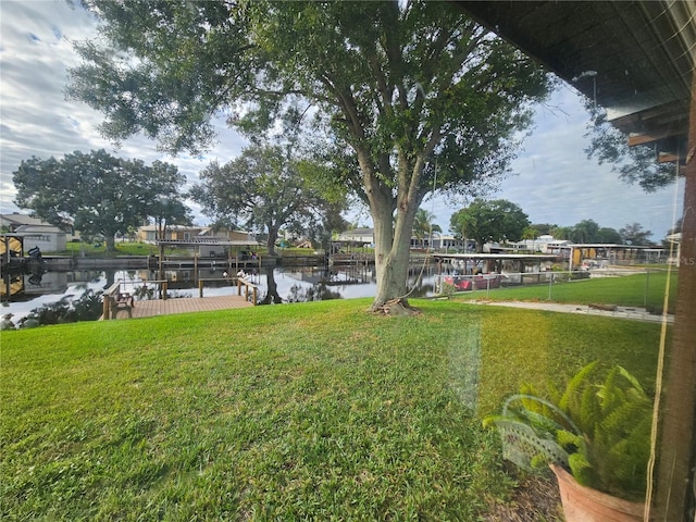 view of yard with a water view and a boat dock