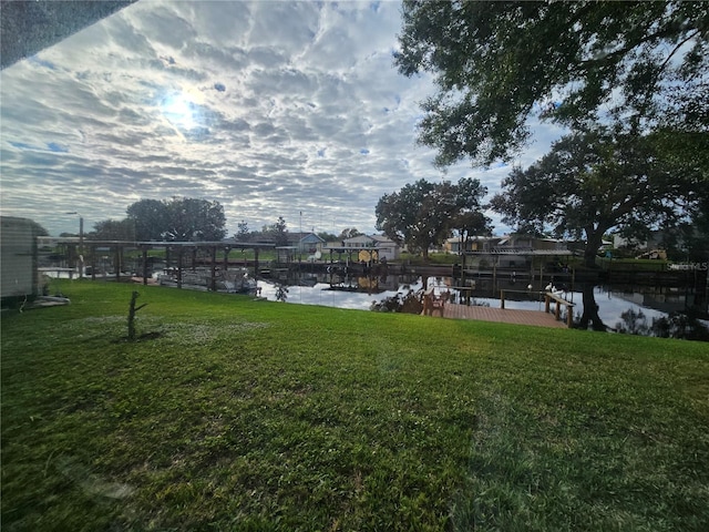 view of yard with a water view and a dock