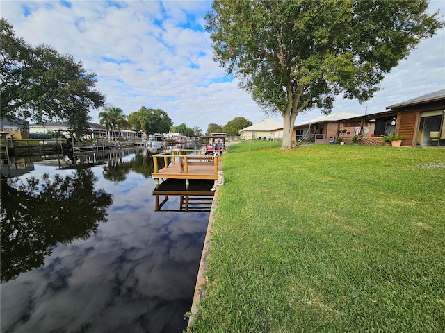 view of dock featuring a water view and a lawn