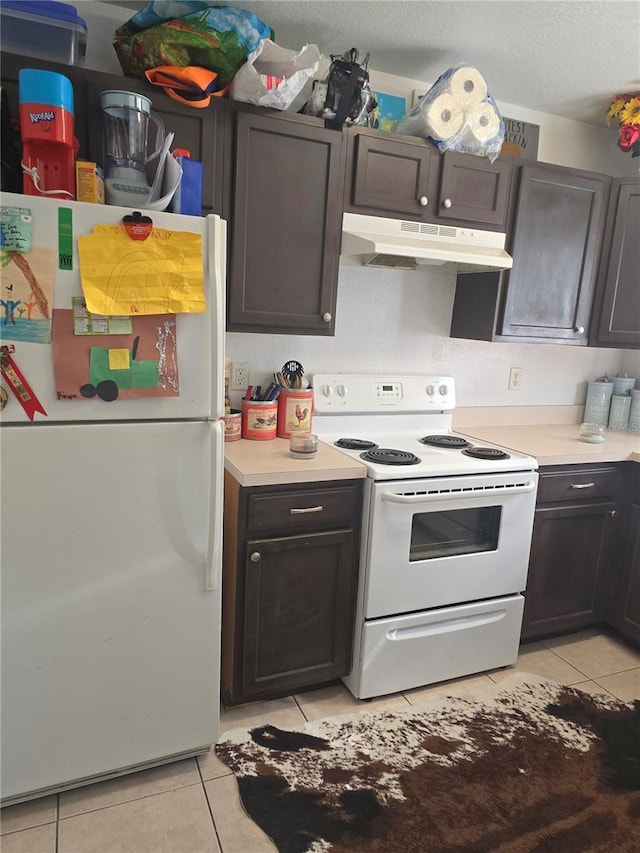 kitchen with a textured ceiling, dark brown cabinets, light tile patterned flooring, and white appliances