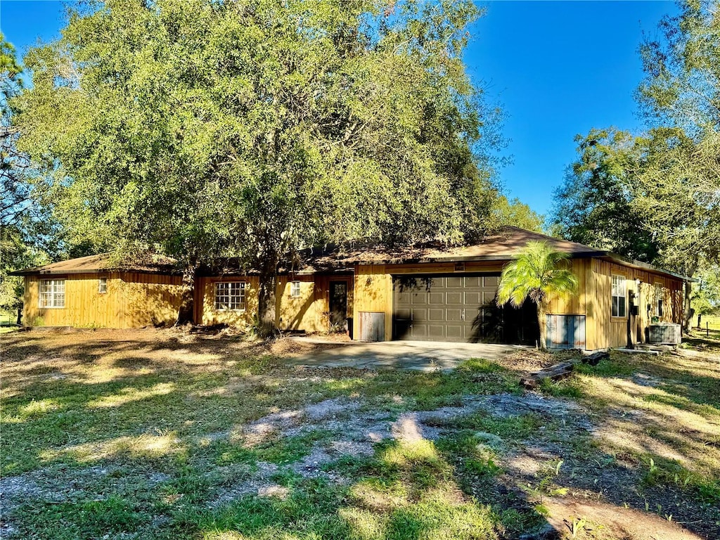 exterior space with a garage and a lawn