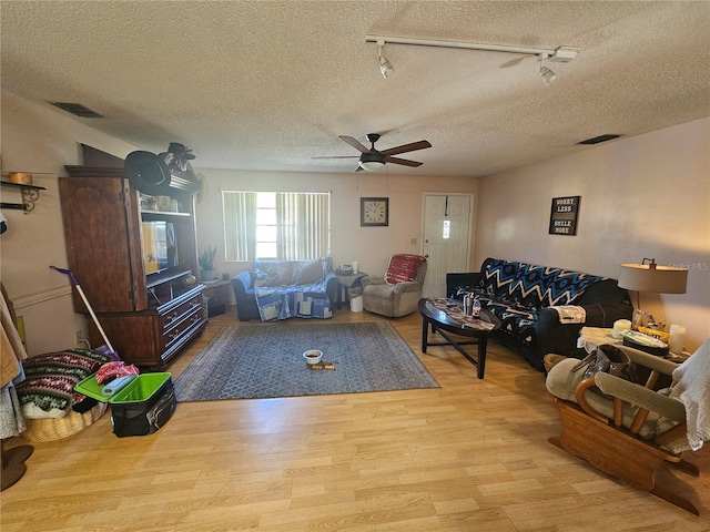 living room featuring a textured ceiling, track lighting, light hardwood / wood-style flooring, and ceiling fan