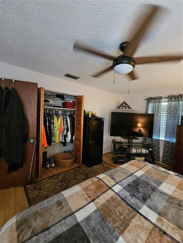 bedroom with ceiling fan, a closet, and a textured ceiling