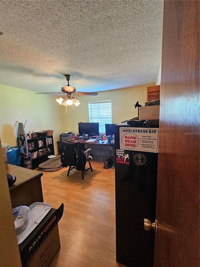 office space featuring ceiling fan, a textured ceiling, and light hardwood / wood-style flooring