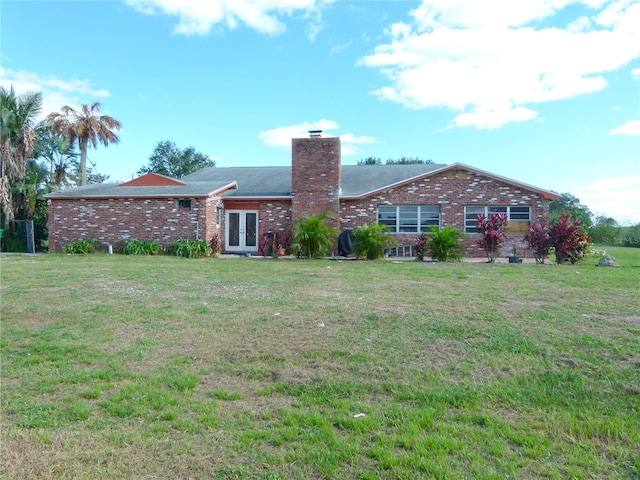 back of house with french doors and a lawn