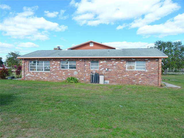 rear view of house featuring a lawn