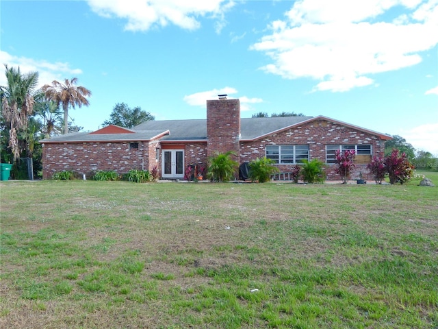 back of house featuring a lawn and french doors