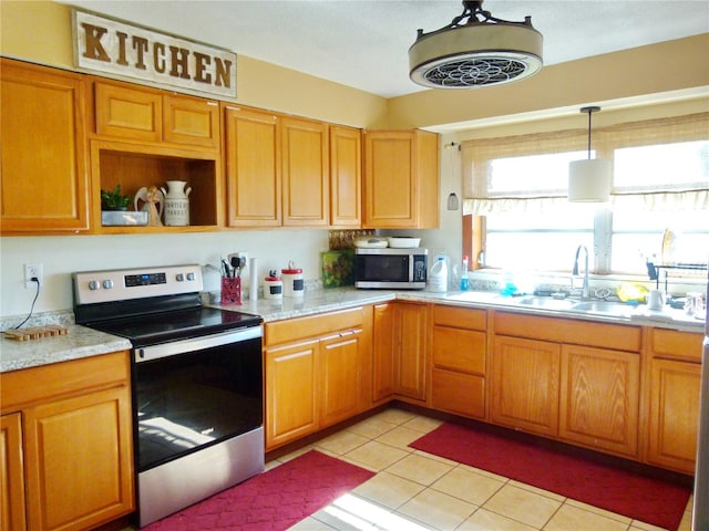 kitchen with sink, hanging light fixtures, light tile patterned flooring, light stone counters, and stainless steel appliances