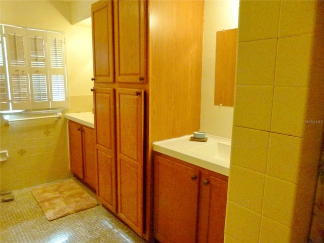 bathroom featuring tile patterned floors, sink, and tile walls