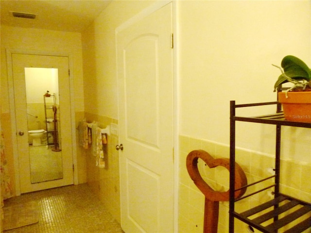 hallway featuring tile patterned floors and tile walls