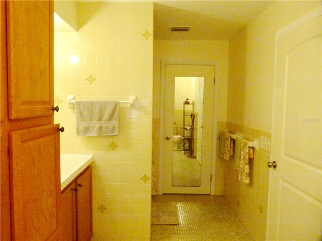 bathroom featuring tile patterned floors, vanity, and tile walls