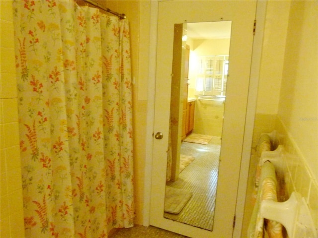 bathroom with tile patterned flooring and tile walls