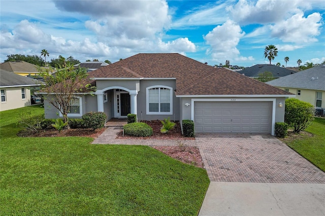 single story home featuring a garage and a front lawn