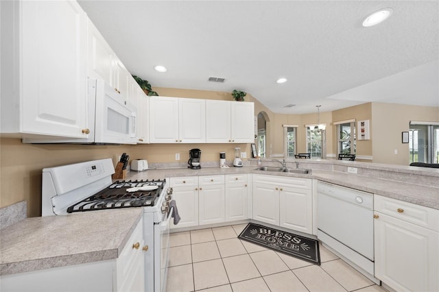 kitchen with plenty of natural light, white cabinets, and white appliances