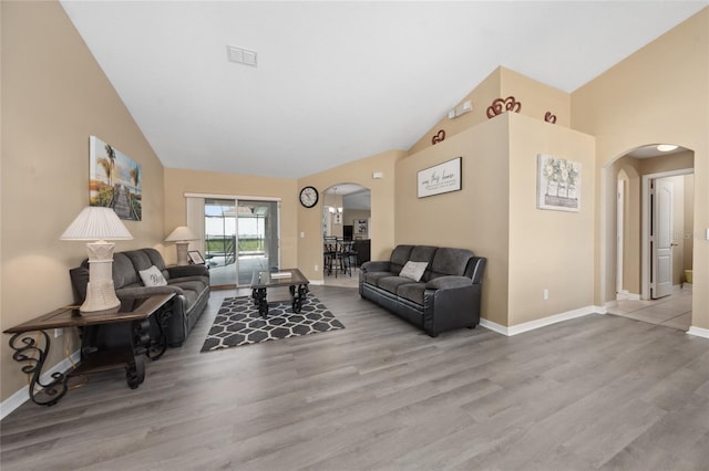 living room with light hardwood / wood-style flooring and high vaulted ceiling