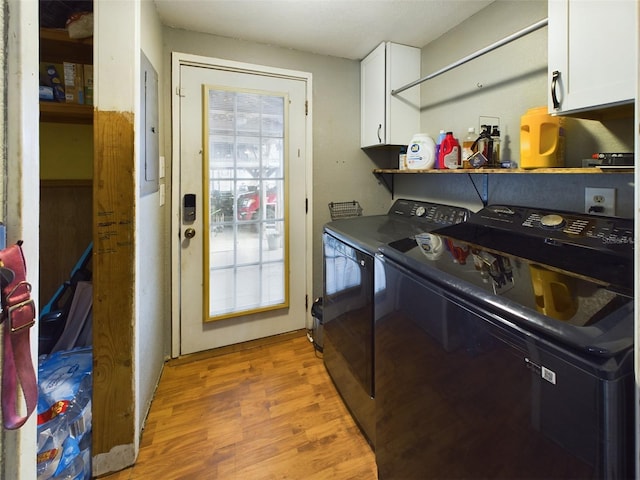 laundry area featuring washer and clothes dryer, light hardwood / wood-style floors, and cabinets