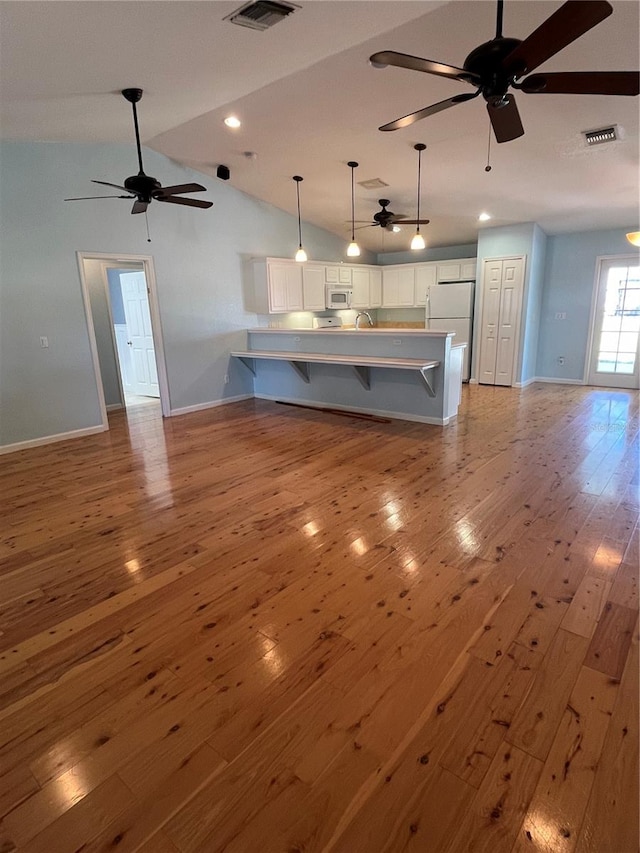 unfurnished living room featuring ceiling fan, light hardwood / wood-style flooring, lofted ceiling, and sink