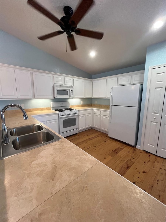 kitchen featuring white appliances, sink, light hardwood / wood-style flooring, white cabinets, and lofted ceiling