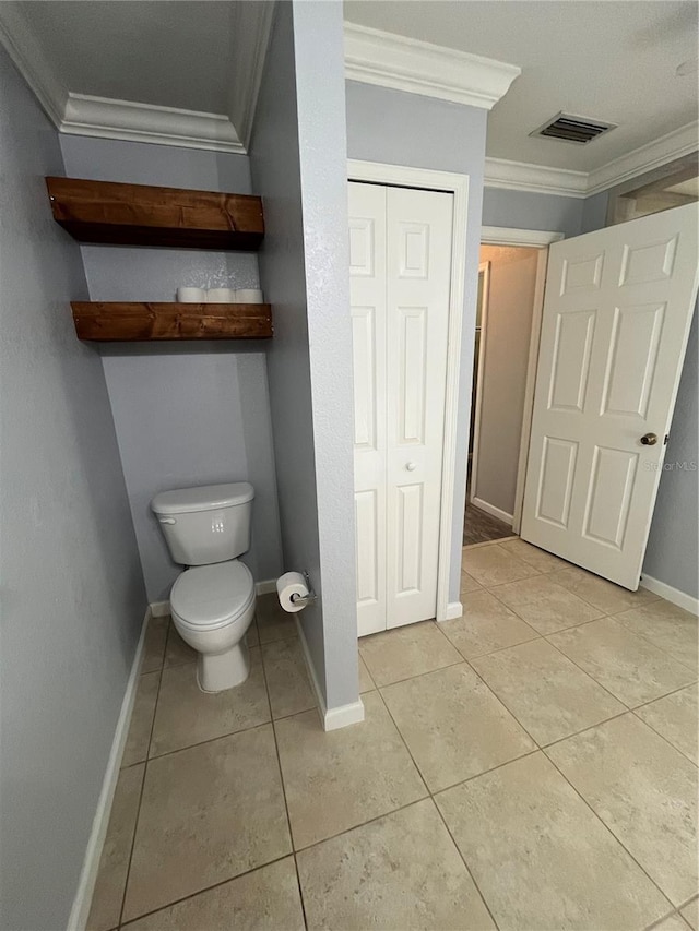 bathroom featuring tile patterned flooring, toilet, and crown molding