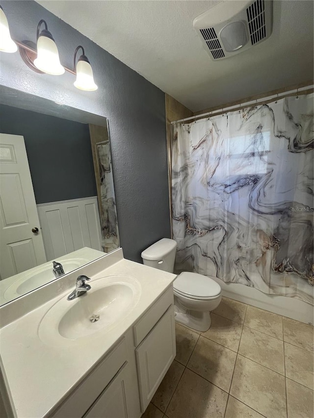 full bathroom with shower / bath combo, tile patterned floors, a textured ceiling, toilet, and vanity