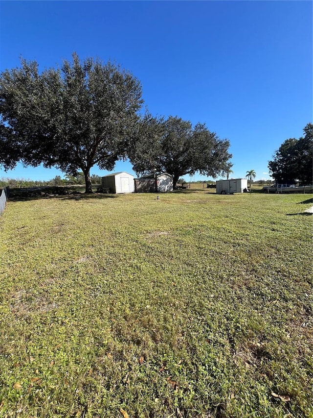 view of yard featuring a rural view and a storage shed