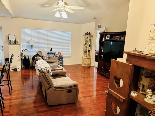 living room with ceiling fan, wood-type flooring, and vaulted ceiling